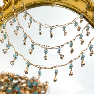 Detail der 4mm Kristallperlenkette mit türkisen Tropfen und goldenen Fransenquasten