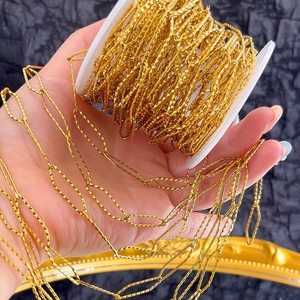 Detailed macro view of gold-plated stainless steel twisted chain link on spool