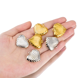 Macro view of textured metallic heart pendants in gold and silver for DIY jewelry