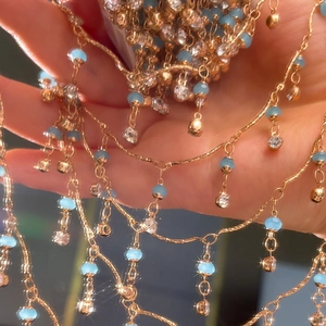 Makro-Detail der 4mm Kristallperlenkette mit blauen Steinen und Goldfransen