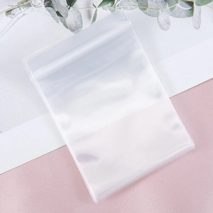 Detailed view of clear PE plastic resealable bag with zipper on minimalist pink background