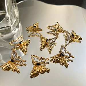 Detaillierte Nahaufnahme goldener Schmetterlingsanhänger mit schwarzem Edelstein und Tinte