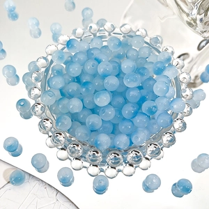 Macro detail of 8mm light blue gradient Czech glass beads with natural ice cracked texture