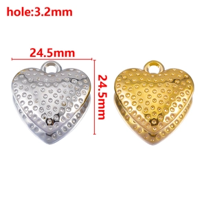 Detail of heart pendants in gold and silver finish with dotted texture and size markings