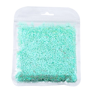 Primo piano di paillettes a cuore vuoto verde menta per nail art e artigianato