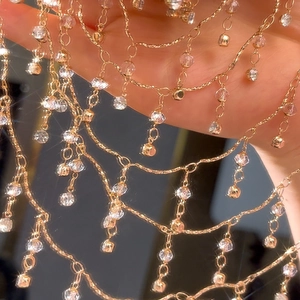 Makroaufnahme einer goldnen Körperkette mit 4mm Kristallperlen und Fransen-Details