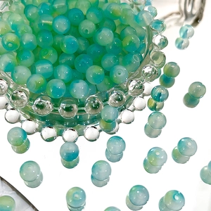 Macro shot of 8mm gradient blue and green Czech glass beads for DIY jewelry making