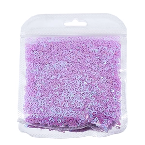 Primo piano di paillettes iridescenti a forma di cuore viola in confezione trasparente