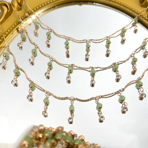 Detaillierte Makroansicht von 4mm grünen Kristallperlen an einer edlen goldkette