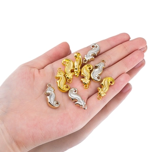 Macro detail of metallic seahorse pendants in gold and silver for DIY jewelry crafts
