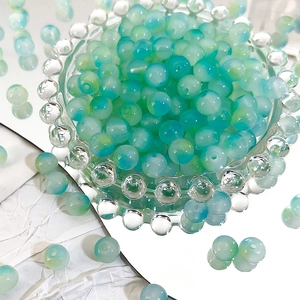 Macro detail of 8mm blue and green gradient Czech glass beads for DIY jewelry making