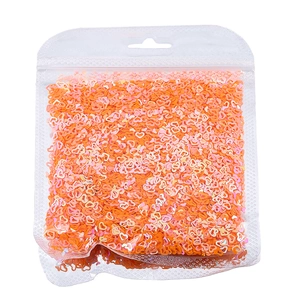 Dettaglio macro di paillettes a forma di cuore arancioni e rosa per nail art e fai da te