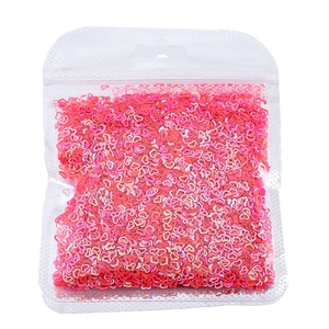 Dettaglio di paillettes a forma di cuore rosso e rosa per nail art e decorazioni DIY