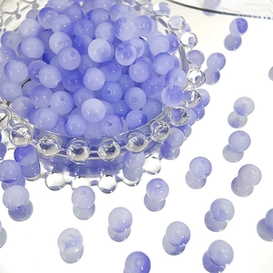 Macro shot of purple 8mm frosted glass beads for DIY jewelry making in a glass bowl