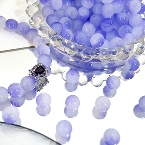 Macro shot of 8mm purple gradient Czech beads and a silver ring with a violet gemstone