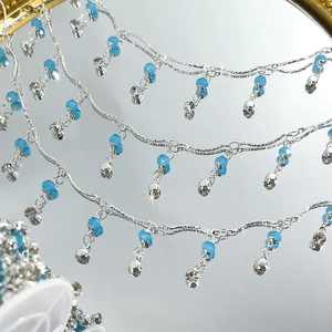 Detail einer 4mm Kristallperlenkette mit himmelblauen Akzenten und schimmernden Quasten