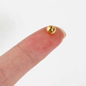 Macro-opname van kleine gouden ronde kralen met gaatjes voor het maken van sieraden