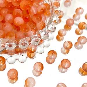 Macro shot of 8mm orange-pink gradient Czech beads with fine frosted texture for DIY crafts
