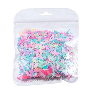 Dettaglio macro di paillettes per unghie a forma di delfino in colori macaron misti