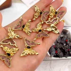 Detailansicht handgehaltener Tintentil-Schmetterlingsanhänger mit goldenem Rahmen