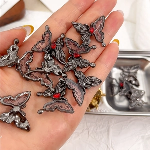 Nahaufnahme der Schmetterling-Legierungsanhänger mit rosa Harzflügeln für DIY-Schmucksets