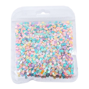 Macro di paillettes colorate a forma di gatto per nail art in una busta trasparente