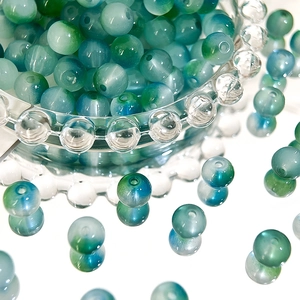 Macro shot of 8mm dual-tone gradient green and blue glass beads for DIY jewelry making