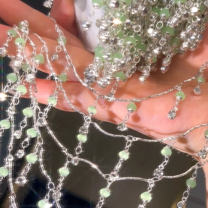 Detail einer DIY-Kette mit 4mm grünen Kristallperlen auf schimmernden silbernen Gliedern