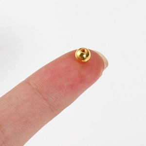 Gepolijste gouden CCB ronde kraal voor DIY sieraden maken getoond op een vingertop