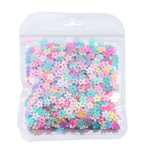 Macro di paillettes colorate a forma di fiori macaron in un sacchetto di plastica trasparente