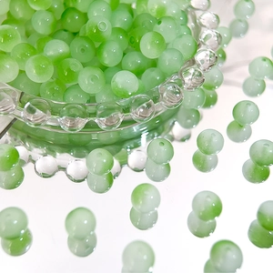 Close-up of 8mm light green gradient Czech glass beads for DIY jewelry making crafts