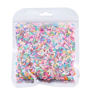 Dettaglio di paillettes per unghie a forma di luna in colori macaron in busta trasparente