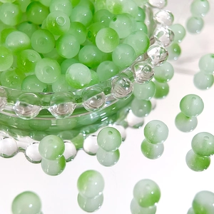 Macro detail of 8mm green gradient Czech glass beads for DIY jewelry making and craft projects
