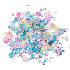 Dettaglio macro di paillettes color pastello a forma di stella e fiore per decorazione unghie