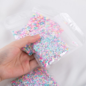 Dettaglio macro di paillettes colorate miste a forma di stella per nail art e artigianato