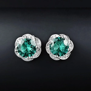Vue détaillée des boucles d'oreilles fleur en argent avec zircones vert foncé