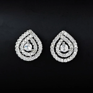 Vue macro de boucles d'oreilles goutte avec sertissage pavé et pierre centrale brillante