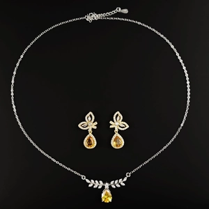 Silver jewelry set with yellow pear-cut zircon pendants and sparkling leaf details