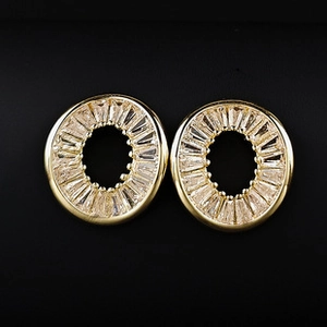 Détail macro de boucles d'oreilles rondes en zircon taille baguette sur fond noir