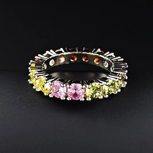 Macro detail of rainbow eternity band with multi-colored gemstones in silver setting