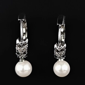 Vue détaillée des boucles d'oreilles argentées en forme de goutte avec zircon et perles blanches