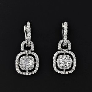 Vue macro de boucles d'oreilles pendantes halo carrées avec pierre ronde sur fond noir