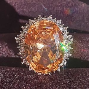 Luxury oval orange gemstone cocktail ring with sparkling halo micro-set zircons
