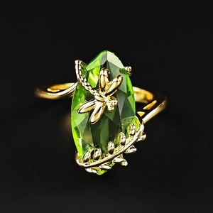 Macro detail of vintage gold dragonfly ring with marquise-cut olive green gemstone