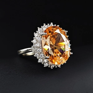 Luxurious silver-plated ring featuring a large oval orange gemstone with halo zircon setting