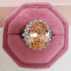 Luxurious oval champagne gemstone ring with halo zircon setting in a pink velvet box