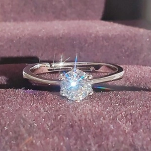 Macro shot of a silver adjustable ring featuring a classic six-prong set round solitaire stone