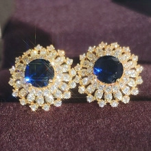 Makro-Detail von Sonnenblumen-Steckern mit tiefblauem Stein und doppeltem Diamantkranz