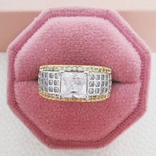 Detailopname van luxe ring met vierkante steen en pavé-zetting in een roze doosje