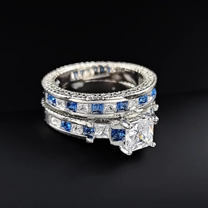 Macro detail of princess cut blue sapphire and white zircon bridal ring set in silver